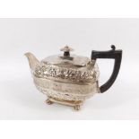 A George III silver teapot, by Robert Cattle and James Barber, the cylindrical body heavily relief