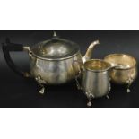 A George V silver three piece tea service in Art Nouveau style, comprising tea pot with ebonised