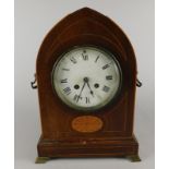 An early 20thC oak lancet shaped mantel clock, with a white enamel dial, two side handles and ogee