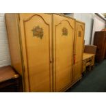 An early 20thC Continental triple wardrobe, painted with flower sprays, on a cream ground, on turned