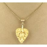 A 19thC carved ivory heart pendant, the carved heart shaped pendant with roses and flowers, with a