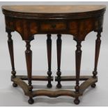 A 20thC walnut tea table in early 18thC style, the demi-lune cross and feather banded top hinged