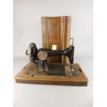 An early 20thC Continental sewing machine, with black and gilt decoration, in walnut case, no