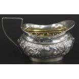 A small Edwardian silver cream jug, with embossed decoration and angular handle, Birmingham 1900,