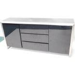 A late 20thC lacquer brushed steel and composite sideboard, with three drawers flanked by two doors,