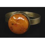 A butterscotch amber set silver bangle, white metal stamped 925, with marks inside
