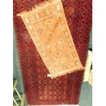 A Turkoman style rug, with three rows of medallions on a deep red ground, 170cm x 88cm, and an