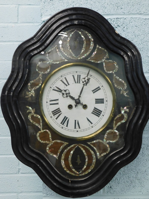A French ebonised wall clock, the white painted dial with Roman numerals, surrounded by mother of