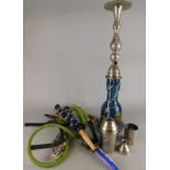 A Middle Eastern Hookah pipe, with a blue glass reservoir and silver coloured metal mounts etc.