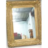 A 19thC gilt gesso picture frame, later inset with a mirrored glass, 115cm x 90cm