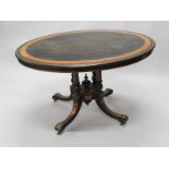 A late 19thC ebonised and amboyna oval breakfast table, the top with a moulded and gilt metal