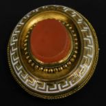 A gilt metal memorial brooch, with enamel and orange agate design to front, a memorial panel to