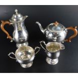 A George VI silver four piece tea set, with gadrooned borders, the teapot with wooden knop and