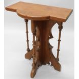 A Victorian gothic style pitch pine side table, with a bow fronted centre, on turned supports,