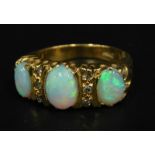 An opal and diamond set dress ring, with three opals and two rows of three illusion set diamonds,