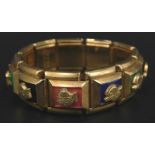 An Empire style expanding gilt metal bracelet, each section with an Empire head on coloured back, on