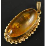 A 9ct gold amber type pendant, with rope twist surround, 2g all in