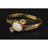 An 18ct gold opal and diamond twist ring, with central opal flanked by two smaller stones and