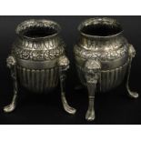 A pair of Continental silver coloured metal vases, each with part fruited decoration and paw feet