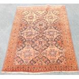 A Turkoman style rug, with a design of flowers and lozenges on a red ground with multiple borders,