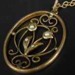 An Art Nouveau pendant and chain, the pendant of flower design, set with seed pearl, on a fine