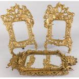 A pair of gilt metal frames, each cast with a knight on horseback etc., 32cm high and a gilt metal