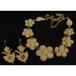 A 1920's/30's costume jewellery floral necklace, and a pair of earrings, each heavily set with cream