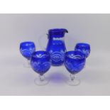 A Continental blue flashed glass water jug and four glasses.