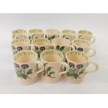 Twelve Emma Bridgewater pottery mugs decorated with holly or ivy.