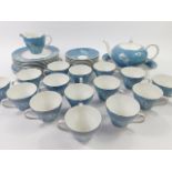 A Simpsons Chinastyle pottery part tea service, decorated with grass sprays against a blue ground,