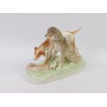 A Royal Dux type porcelain figure group modelled as two hounds with a dead hare, raised on a