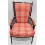 A Continental bergere type armchair, with a checked patterned padded back, arm rests and seat, on