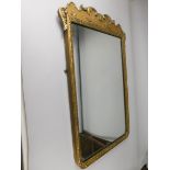 A giltwood wall mirror, with rectangular plate and shaped crest