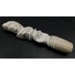 A small carved lava handle, decorated with a Romanesque type figure wearing a wreath etc., 9cm long