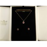 An 18ct gold ruby and diamond pendant and earring set, formed in a floral cluster, with central