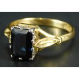 An 18ct gold dress ring, with claw set sapphire, in white metal setting, on a yellow metal band,