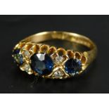 An 18ct gold dress ring, set in the gypsy style, with sapphires and diamonds, with pierced surround,