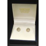 A pair of 14k gold diamond set earrings, each in the form of an oval, illusion set in white metal