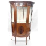 An Edwardian mahogany and ebony strung bow fronted display cabinet, with single part glazed door, on
