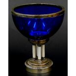 A 19thC German blue glass pedestal bowl, with white metal collar, on four white guilloche enamel