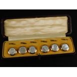 A set of mother of pearl collar studs, on gold plated backs, in a fitted case.