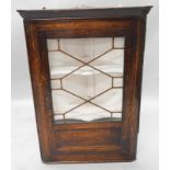 An early 19thC oak corner cupboard, with a single glazed door, enclosing a painted interior, 69cm