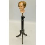 A late 19th and early 20thC ebonised mannequin stand, later inset with a painted dummy's head,