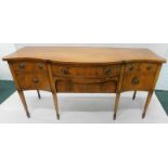 A mahogany sideboard in George III style, the serpentine fronted top with a cross banded, ebony