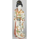 A 19thC Japanese porcelain Meiji figure, of a geisha girl and a kitten, with an elaborately