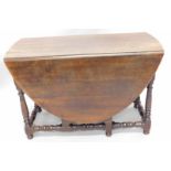 An 18thC oak drop leaf table, with an associated oval top, above a frieze drawer on turned supports,