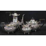 An Edwardian silver four piece tea service, with part fluted and embossed decoration and vacant