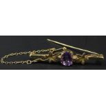 A 9ct gold bar brooch, with central amethyst stone and two leaf design, 4.1g all in.