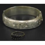 Two items of silver jewellery, to include a florally engraved bangle, and a blue stone set dress