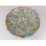 An Iznik style charger, decorated in green, blue and yellow, with arches etc., old restoration, 42cm